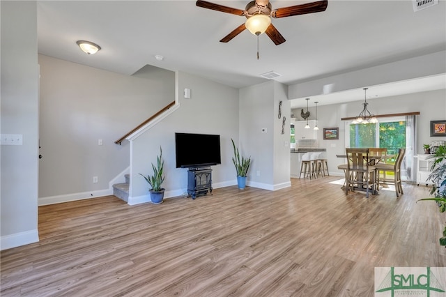 unfurnished living room with light hardwood / wood-style flooring and ceiling fan with notable chandelier