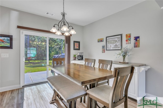 dining room featuring a notable chandelier and light wood-type flooring