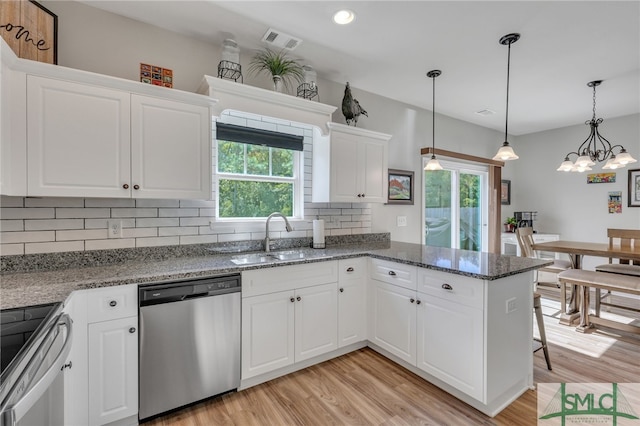 kitchen with a wealth of natural light, white cabinetry, hanging light fixtures, and stainless steel appliances