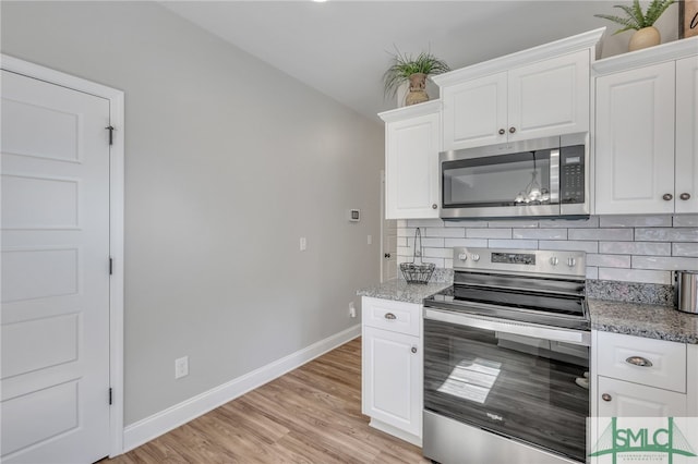 kitchen featuring decorative backsplash, light stone counters, white cabinetry, light wood-type flooring, and stainless steel appliances