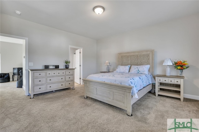 bedroom with light carpet and ensuite bath