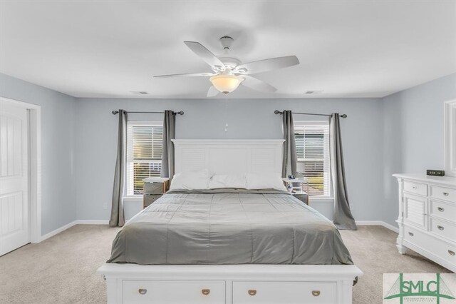 carpeted bedroom featuring multiple windows and ceiling fan