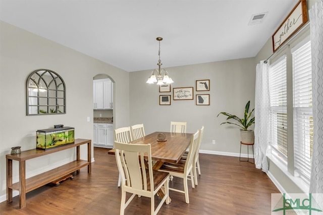 dining space featuring dark hardwood / wood-style flooring and a chandelier