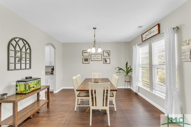 dining area with a chandelier and dark wood-type flooring