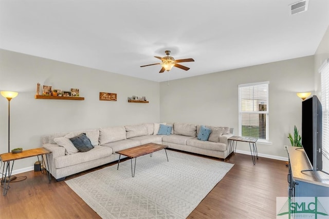 living room with dark wood-type flooring and ceiling fan