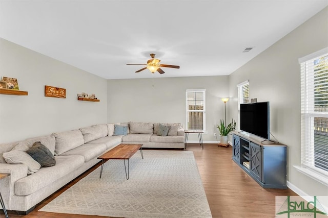 living room featuring wood-type flooring and ceiling fan