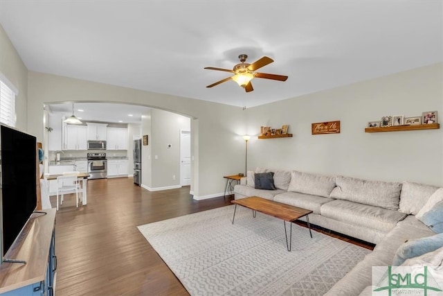 living room featuring sink, ceiling fan, and dark hardwood / wood-style flooring