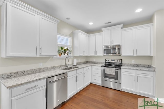 kitchen featuring white cabinetry, appliances with stainless steel finishes, sink, and dark wood-type flooring