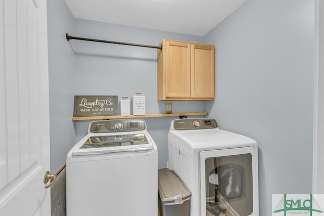 laundry area with washer and dryer and cabinets