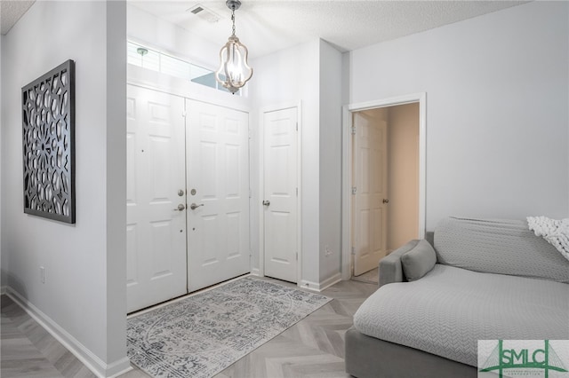 foyer entrance with a textured ceiling and light parquet flooring