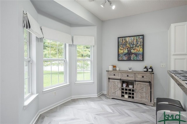 sitting room with a textured ceiling and light parquet floors