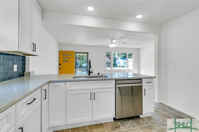 kitchen featuring kitchen peninsula, white cabinets, backsplash, stainless steel dishwasher, and sink