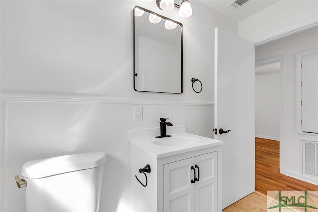 bathroom featuring vanity, toilet, and hardwood / wood-style floors