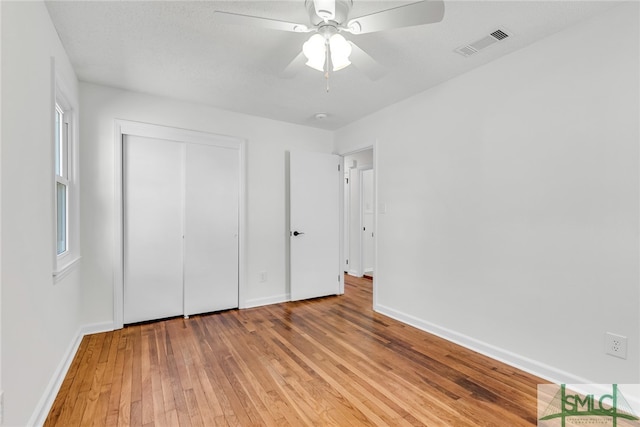 unfurnished bedroom with light hardwood / wood-style flooring, a closet, and ceiling fan