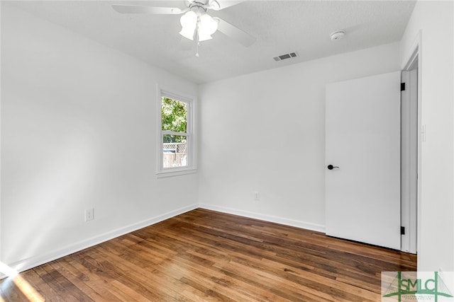 spare room with a textured ceiling, hardwood / wood-style flooring, and ceiling fan