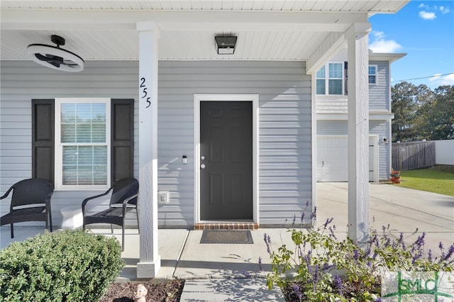 doorway to property featuring covered porch and a garage