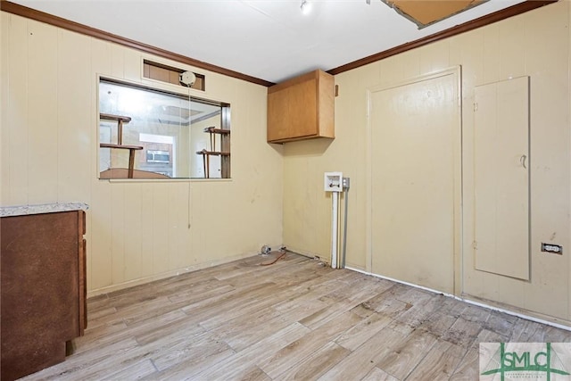 laundry room featuring cabinets, wooden walls, light wood-type flooring, and ornamental molding