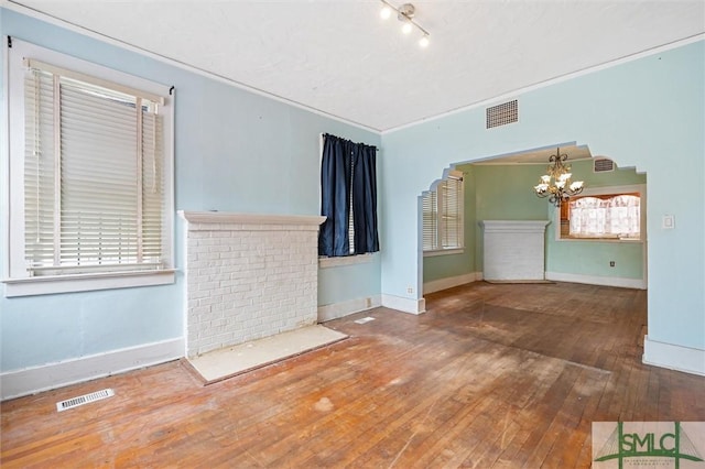 unfurnished living room with hardwood / wood-style floors and an inviting chandelier