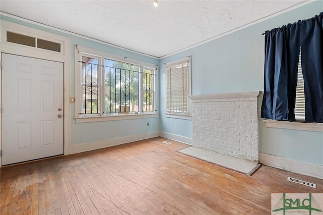 entryway with wood-type flooring and ornamental molding