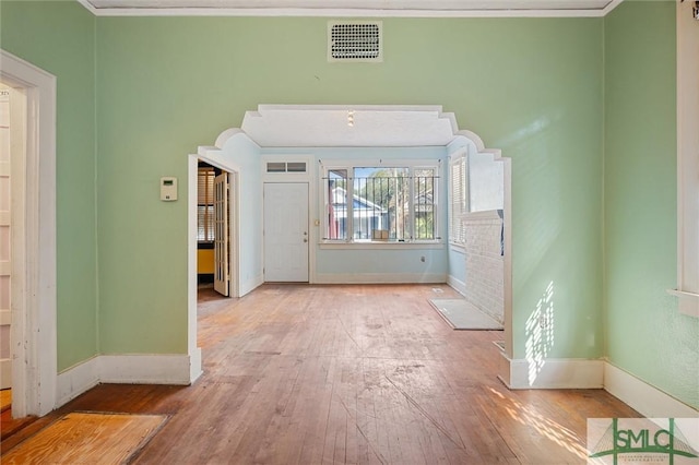 interior space with crown molding and light hardwood / wood-style floors