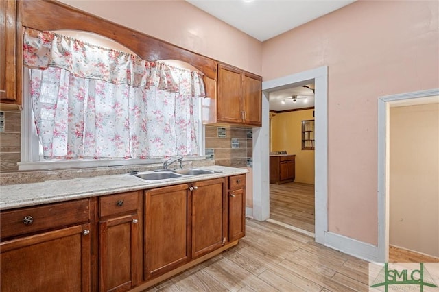 kitchen featuring light hardwood / wood-style floors, light stone countertops, and sink