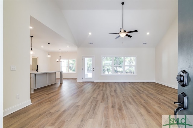 unfurnished living room with high vaulted ceiling, light wood-type flooring, and ceiling fan