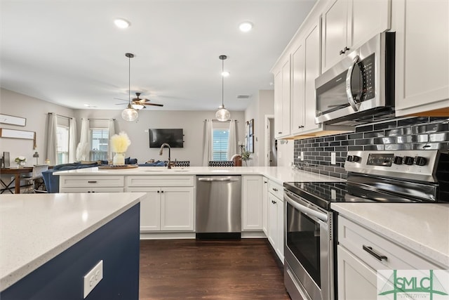 kitchen featuring dark hardwood / wood-style floors, hanging light fixtures, stainless steel appliances, white cabinets, and ceiling fan