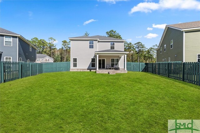 back of property with a patio area and a lawn