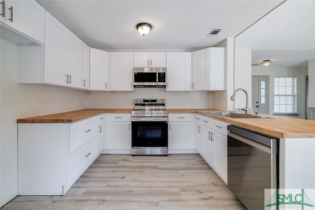 kitchen featuring sink, white cabinetry, kitchen peninsula, and stainless steel appliances