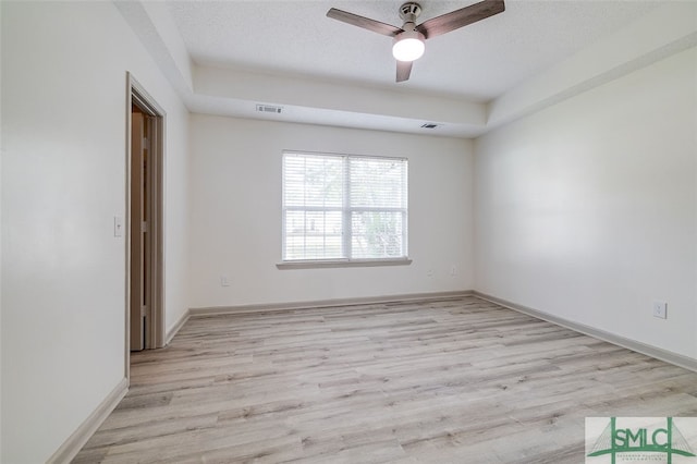 spare room with ceiling fan, a textured ceiling, and light hardwood / wood-style flooring