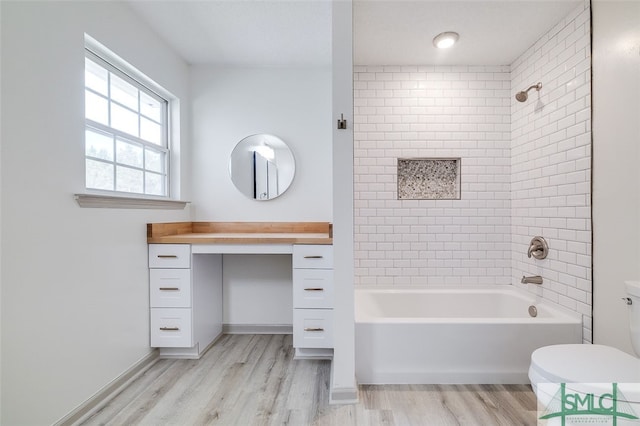 full bathroom featuring toilet, tiled shower / bath, vanity, and wood-type flooring