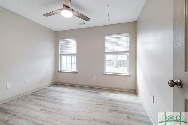 empty room with ceiling fan, a textured ceiling, and light hardwood / wood-style flooring