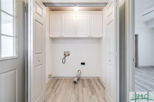 laundry room featuring hookup for a washing machine, cabinets, light hardwood / wood-style flooring, and hookup for an electric dryer