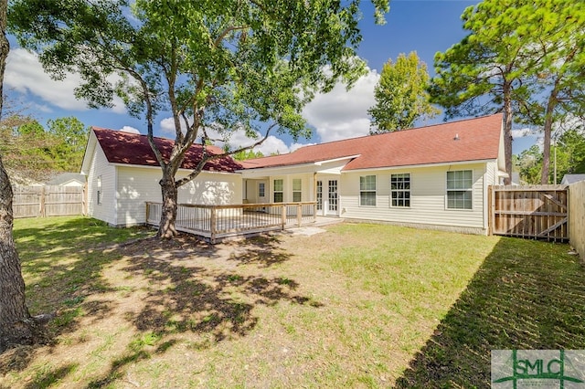 rear view of house with a wooden deck and a yard