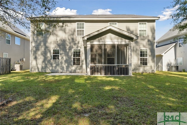 rear view of property with a yard, a sunroom, and central AC unit