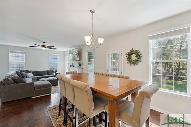 dining area featuring dark hardwood / wood-style floors, ceiling fan with notable chandelier, and plenty of natural light