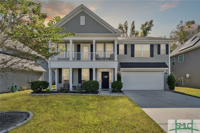 view of front of house featuring a yard, a balcony, and a garage