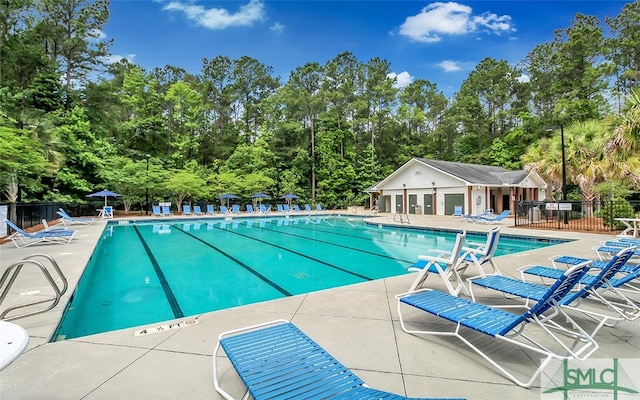 view of pool with a patio and an outdoor structure