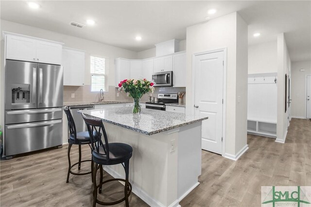110 Benelli Dr, Pooler, GA 31322 - kitchen with a kitchen island, visible vents, appliances with stainless steel finishes, a sink, and white cabinets
