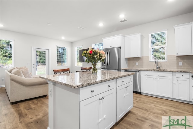 kitchen with sink, white cabinetry, light hardwood / wood-style flooring, and stainless steel appliances