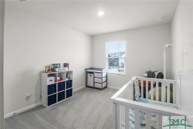 bedroom with light carpet and a nursery area