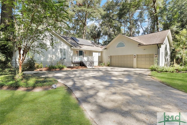 view of front facade with solar panels, a front yard, and a garage