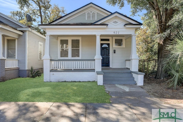 bungalow-style home with a front lawn and covered porch