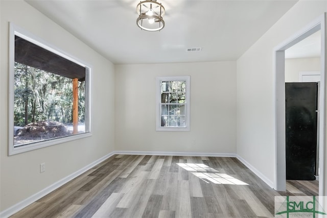 unfurnished dining area featuring hardwood / wood-style floors and a notable chandelier