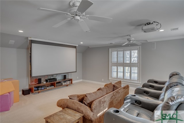 home theater featuring light carpet, crown molding, and ceiling fan