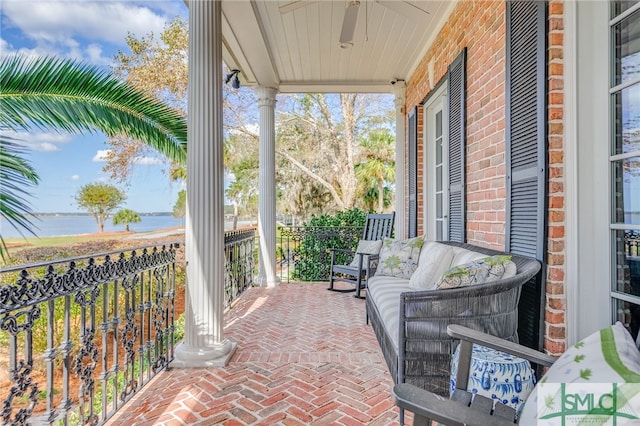 view of patio / terrace with a porch, a water view, and ceiling fan