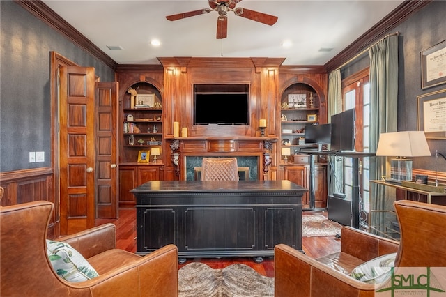 living room with hardwood / wood-style flooring, ornamental molding, built in features, a fireplace, and ceiling fan