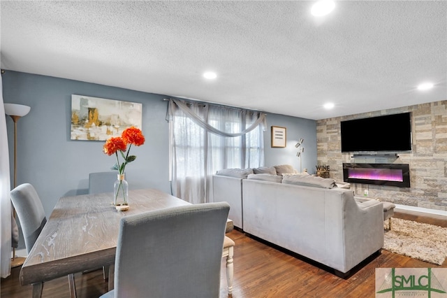 dining room featuring a textured ceiling, wood-type flooring, and a fireplace