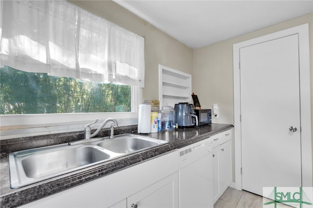 kitchen with white cabinetry, dishwasher, and sink