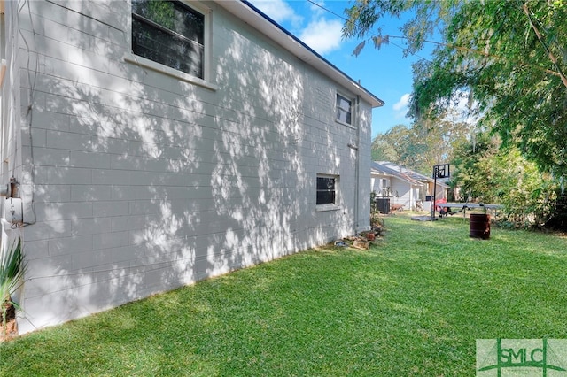 view of property exterior with a yard and central AC unit